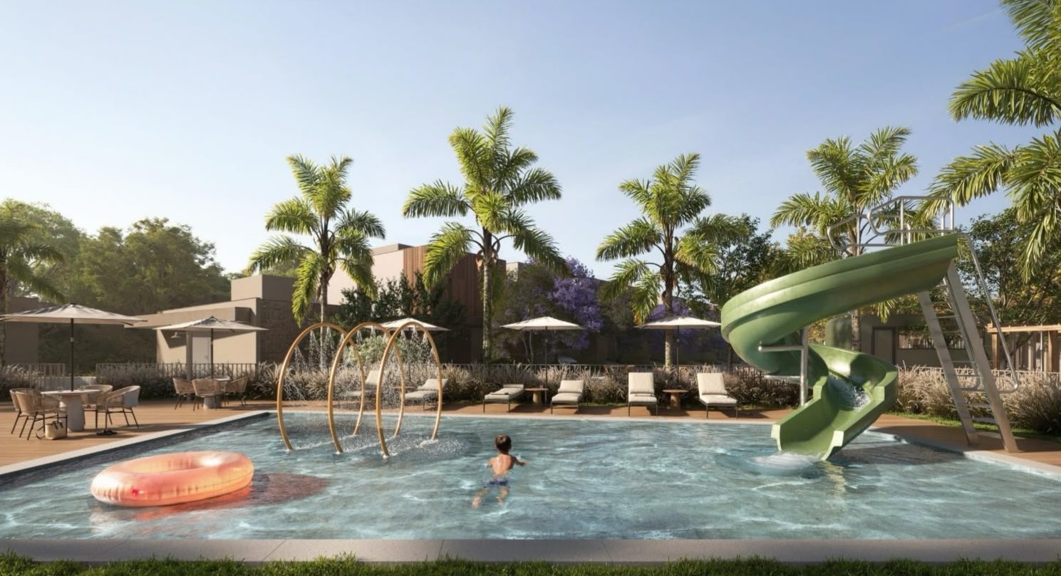 Piscina infantil com toboágua verde e acqua play do Abitte Piemonte, cercada de palmeiras